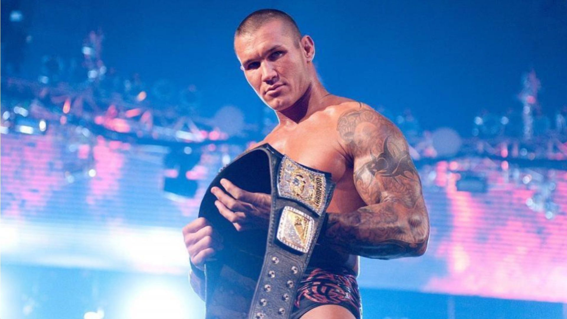 Randy Orton holding the WWE Championship at an event.