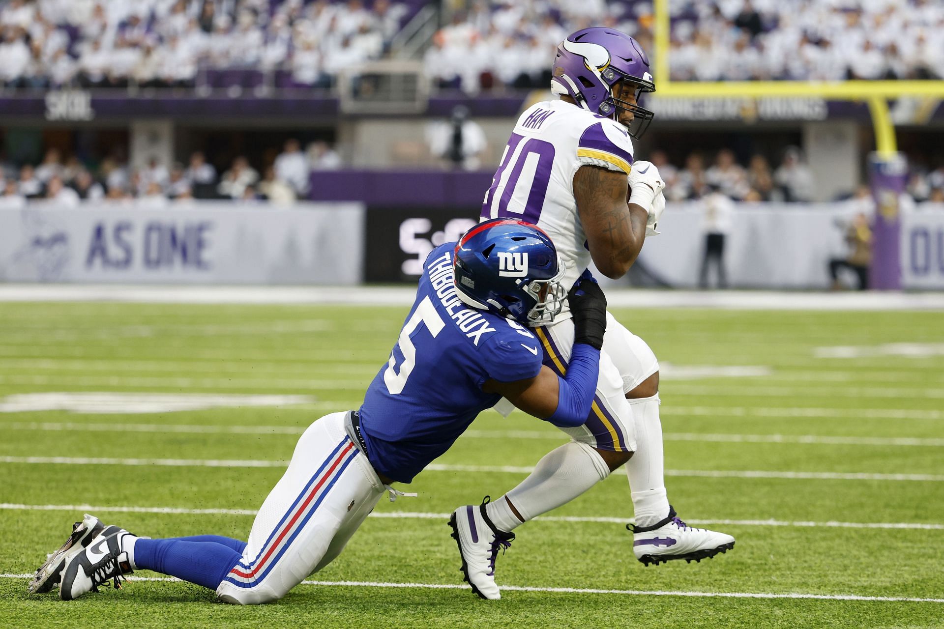 Kayvon Thibodeaux #5 of the New York Giants tackles C.J. Ham #30 of the Minnesota Vikings