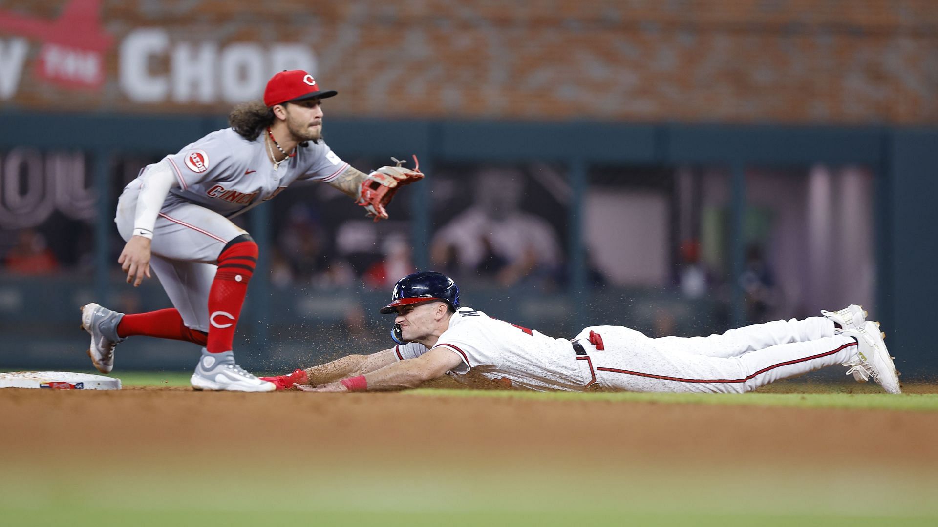 Sam Hilliard of the Atlanta Braves slides in to steal second under Jonathan India of the Cincinnati Reds.