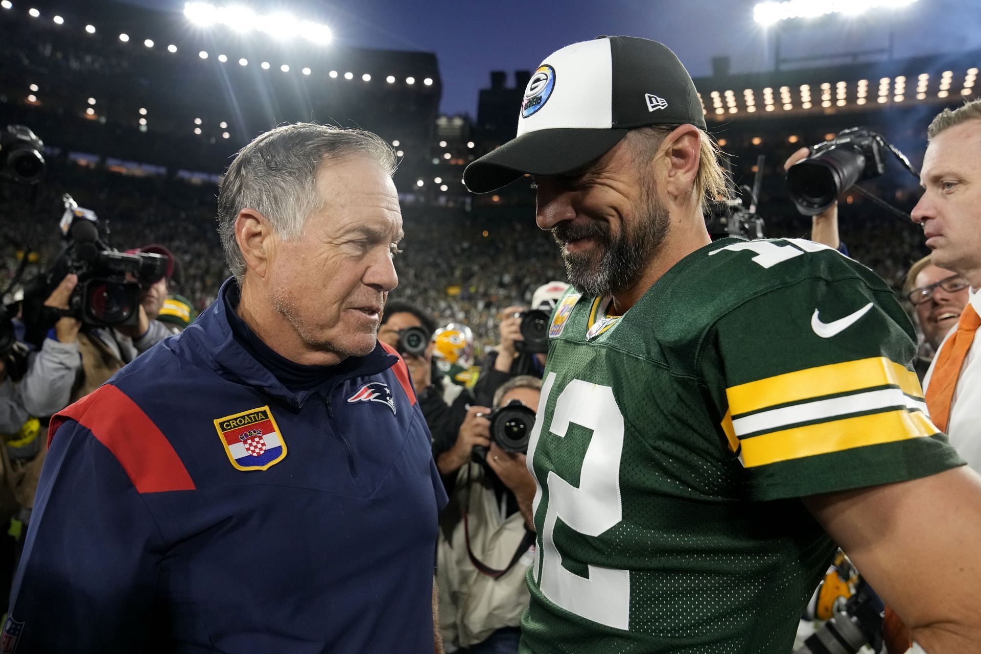 Head coach Bill Belichick of the New England Patriots and Aaron Rodgers #12 of the Green Bay Packers talk after Green Bay&#039;s 27-24 win in overtime at Lambeau Field on October 02, 2022