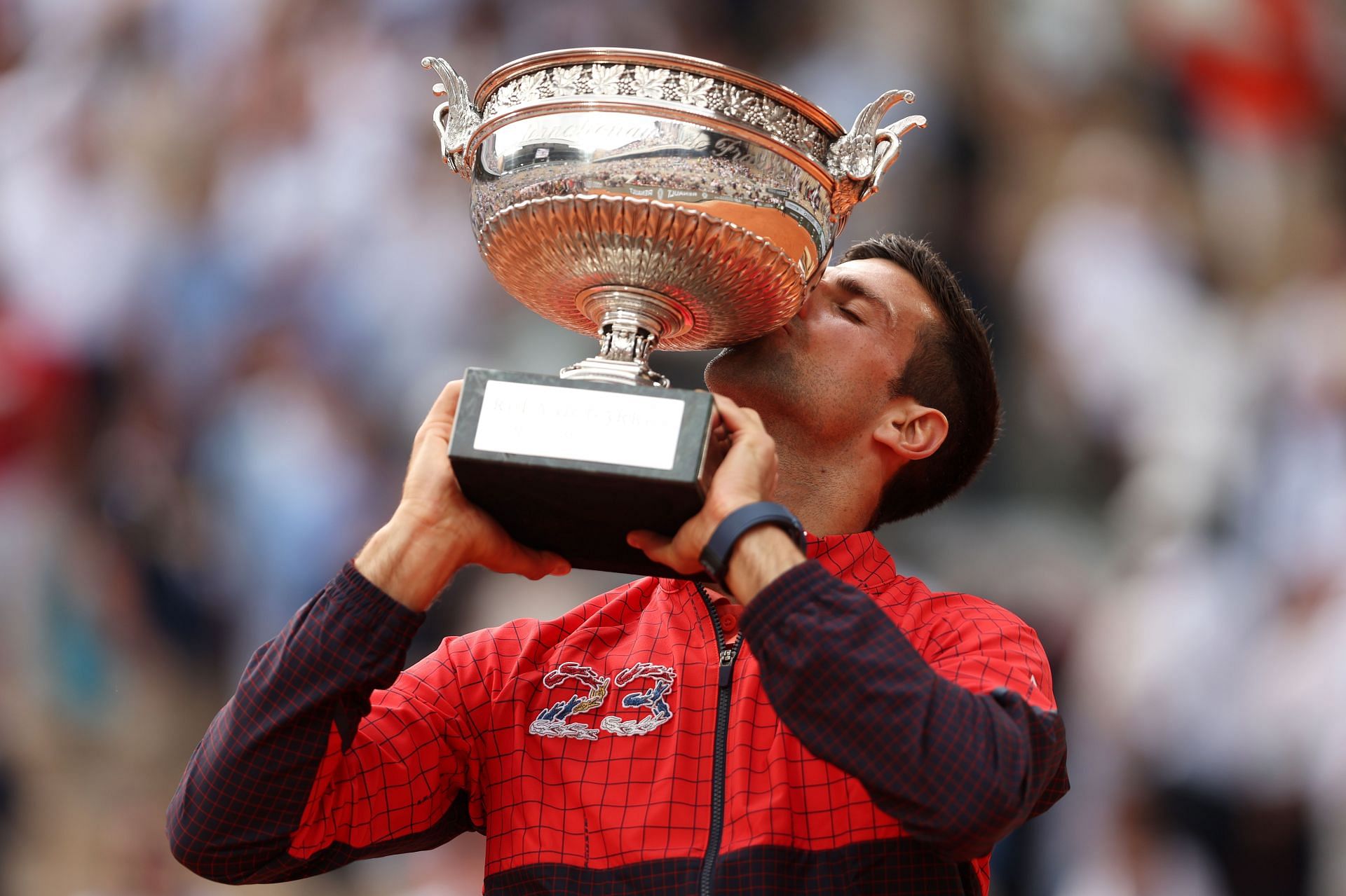 Djokovic hoists aloft the Roland Garros trophy.