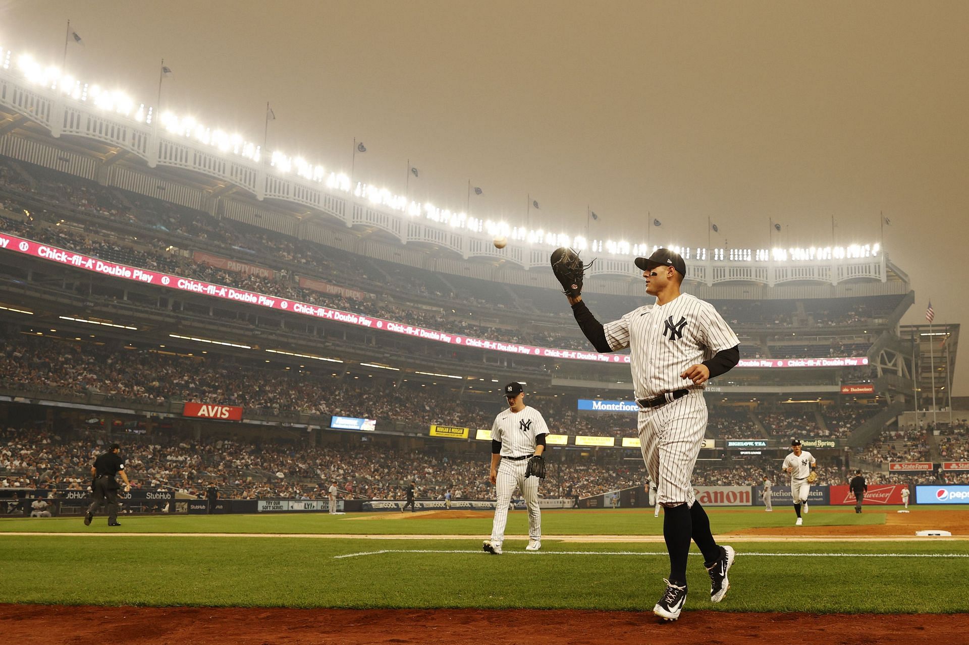 General view of hazy conditions resulting from Canadian wildfires as Anthony Rizzo of the New York Yankees jogs to the dugout.