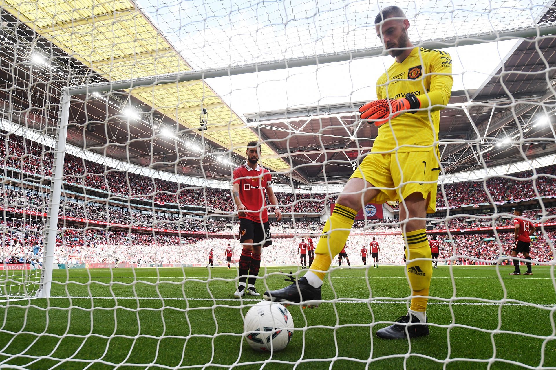 Manchester United goalkeeper David de Gea picks the ball out of the back of the net after conceding.