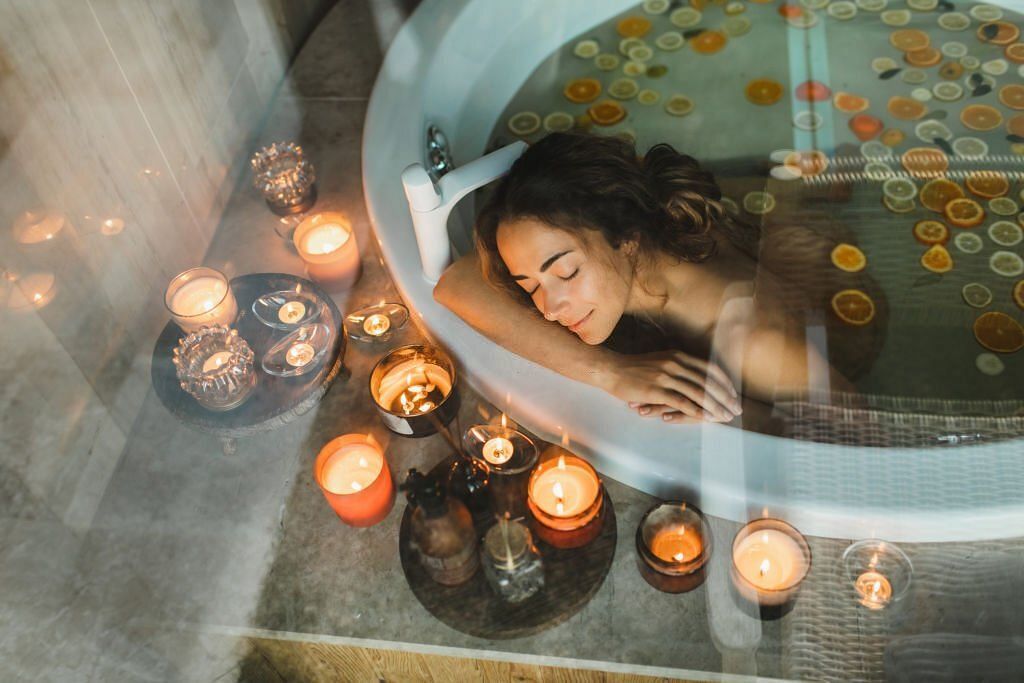 young woman relaxing in hot tub-bath and practising aromatherapy to prevent anxiety 