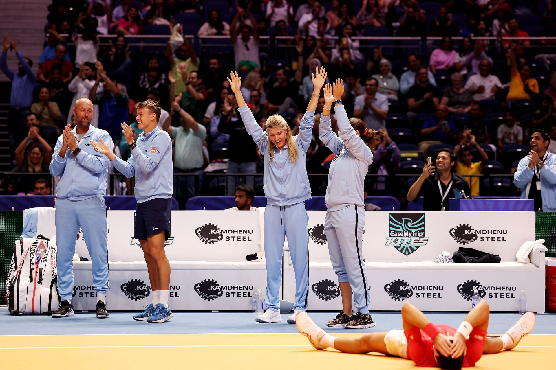 Eugenie Bouchard celebrates at the World Tennis League as Novak Djokovic competes for a point