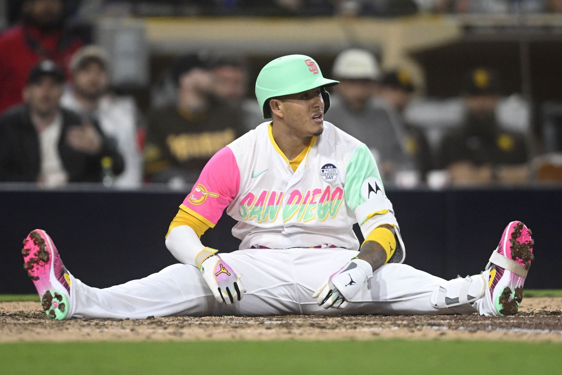 Manny Machado of the San Diego Padres sits on the ground after being brushed back by a pitch at Petco Park