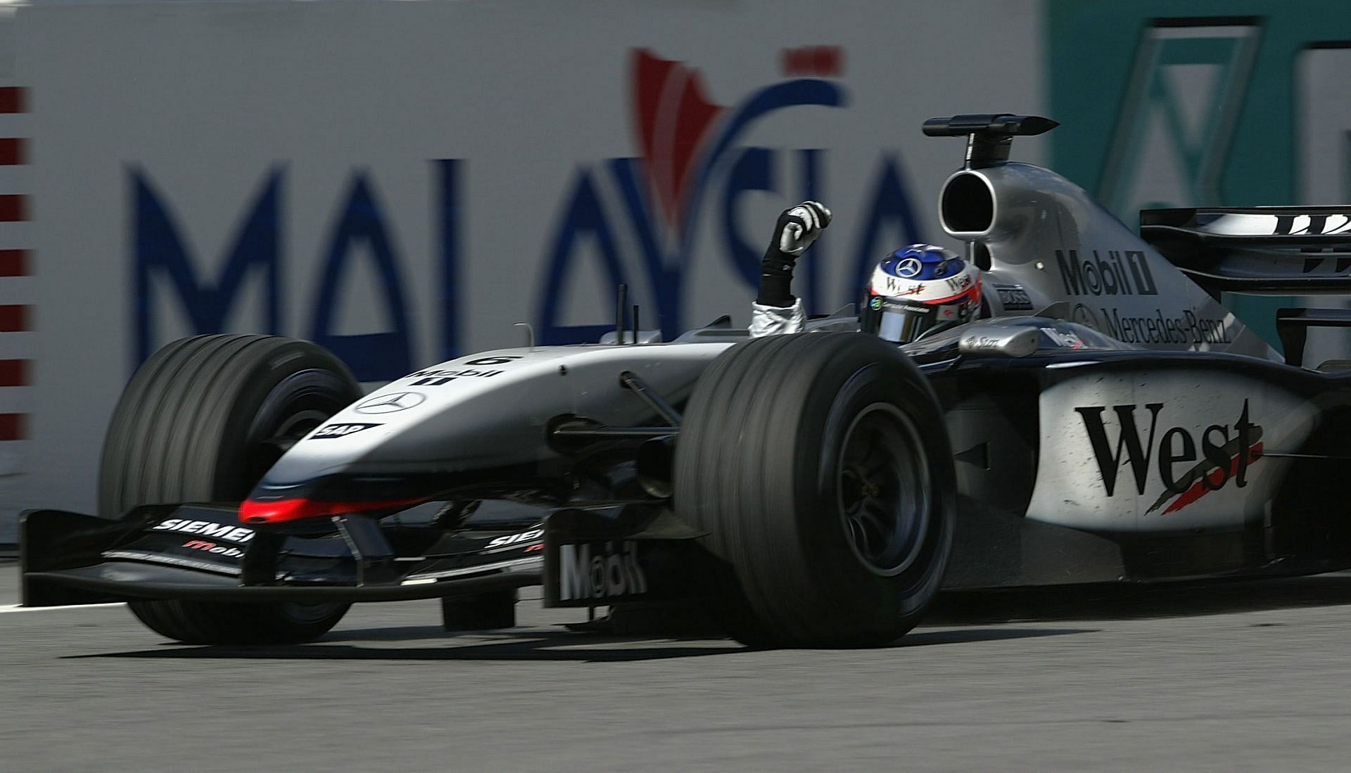 Raikkonen celebrating his maiden win during the 2003 Malaysian Grand Prix (Photo by Mark Thompson/Getty Images)