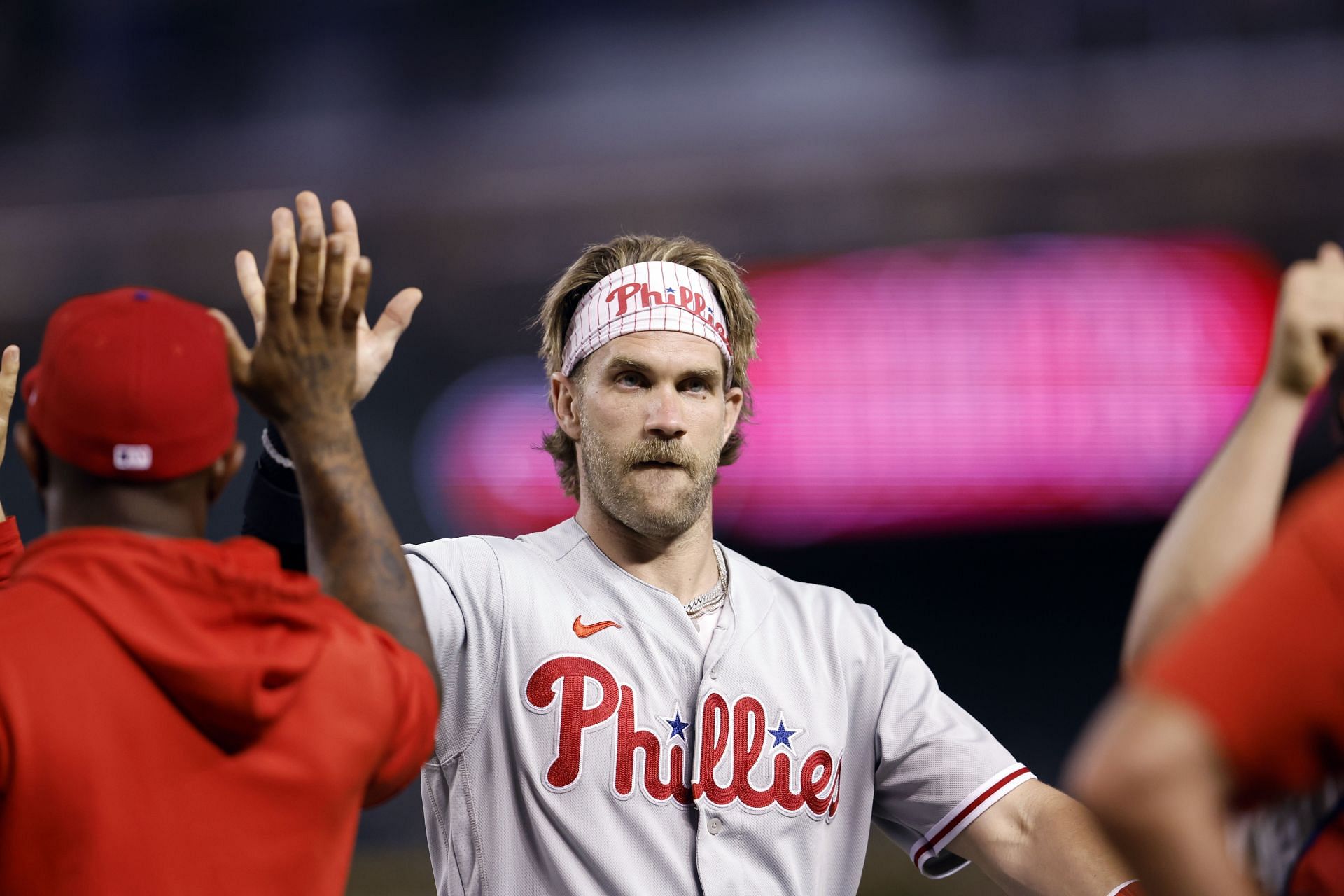 Bryce Harper of the Philadelphia Phillies high fives teammates after a win over the Arizona Diamondbacks at Chase Field