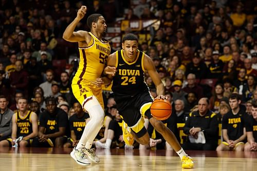 Kris Murray of the Iowa Hawkeyes drives to the basket while Ta'lon Cooper of the Minnesota Golden Gophers defends