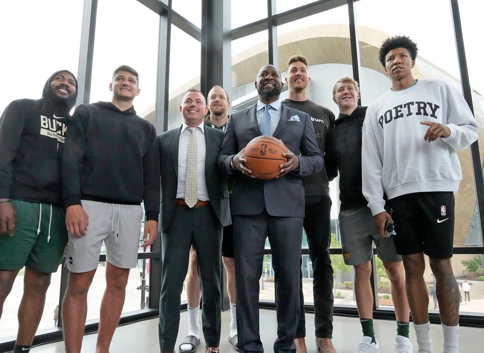 Adrian Griffin posing with Milwaukee Bucks players and staff at his introductory press conference on Tuesday.
