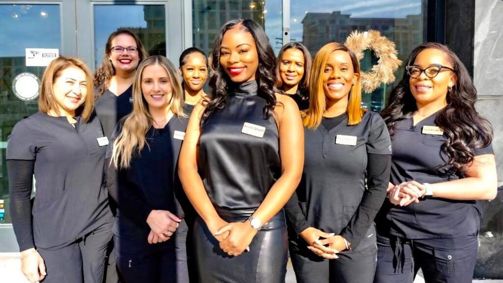 Keiana Stewart, who will be joining RHOP season 8, with the staff of her beauty salon K. Stewart Beauty &amp; Wellness (Image via K. Stewart Beauty &amp; Wellness)