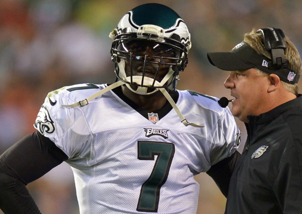 Michael Vick being given instructions by his coach