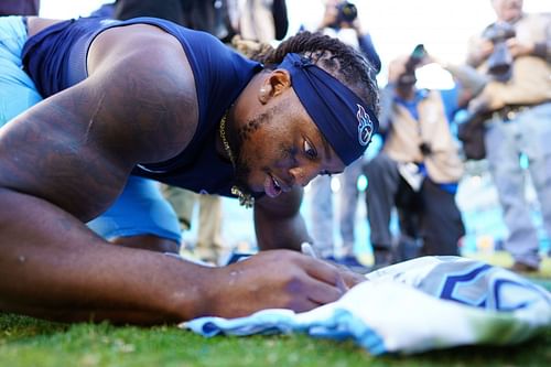 Derrick Henry signs Christian McCaffrey's jersey at Tennessee Titans vs. Carolina Panthers.