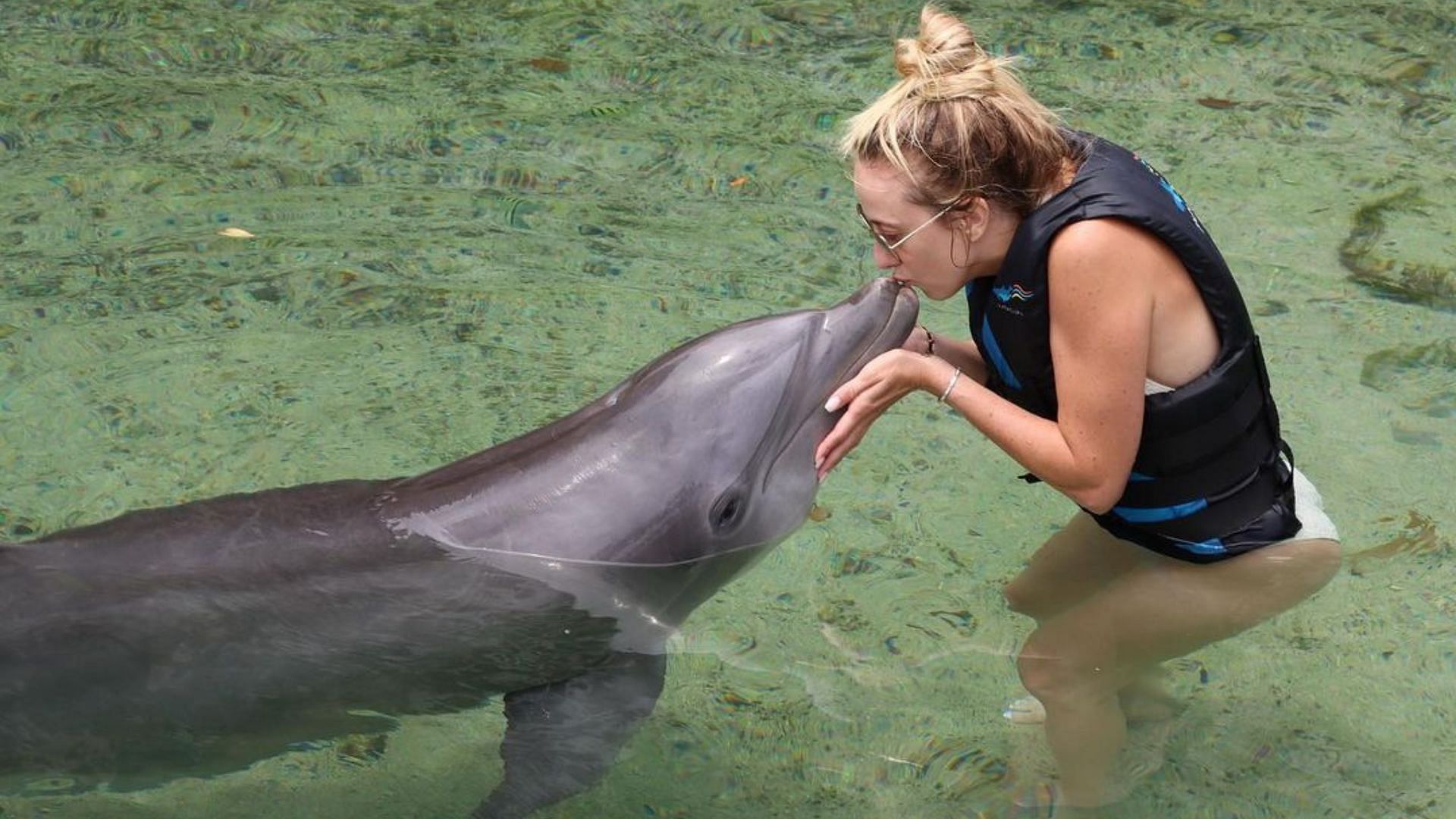 Brittany Mahomes kisses a dolphin during a recent trip. (Image credit: brittanylynne/Instagram)