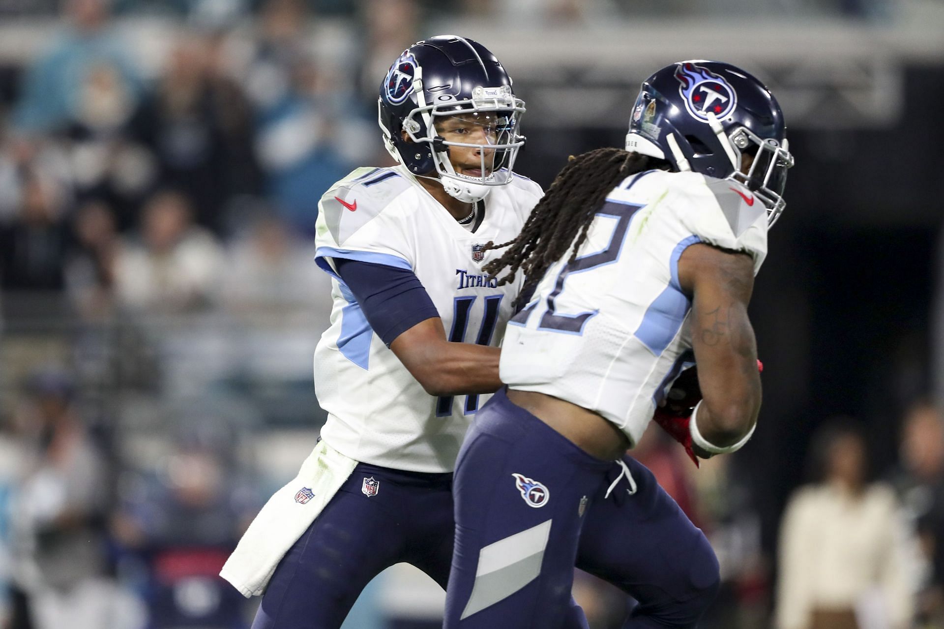 Joshua Dobbs, #11 of the Tennessee Titans, hands the ball off Derrick Henry, #22 of the Tennessee Titans, during the second quarter against the Jacksonville Jaguars at TIAA Bank Field on January 07, 2023, in Jacksonville, Florida.