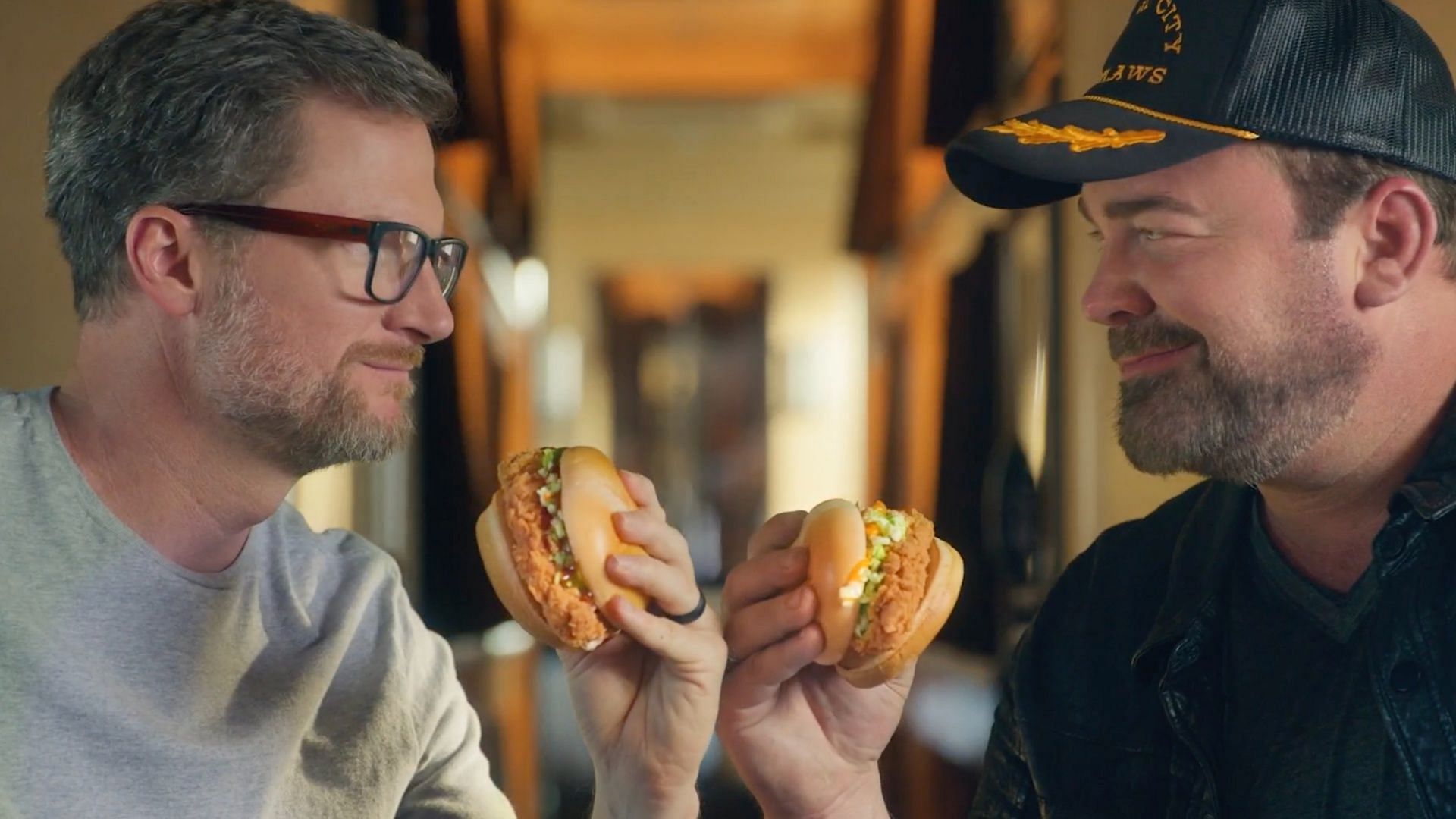 The new Bo&#039;s Chicken Sandwich TV spot features the two Carolina legends - GRAMMY-nominated Lee Brice and the popular NASCAR driver Dale Earnhardt Jr. (Image via Bojangles)