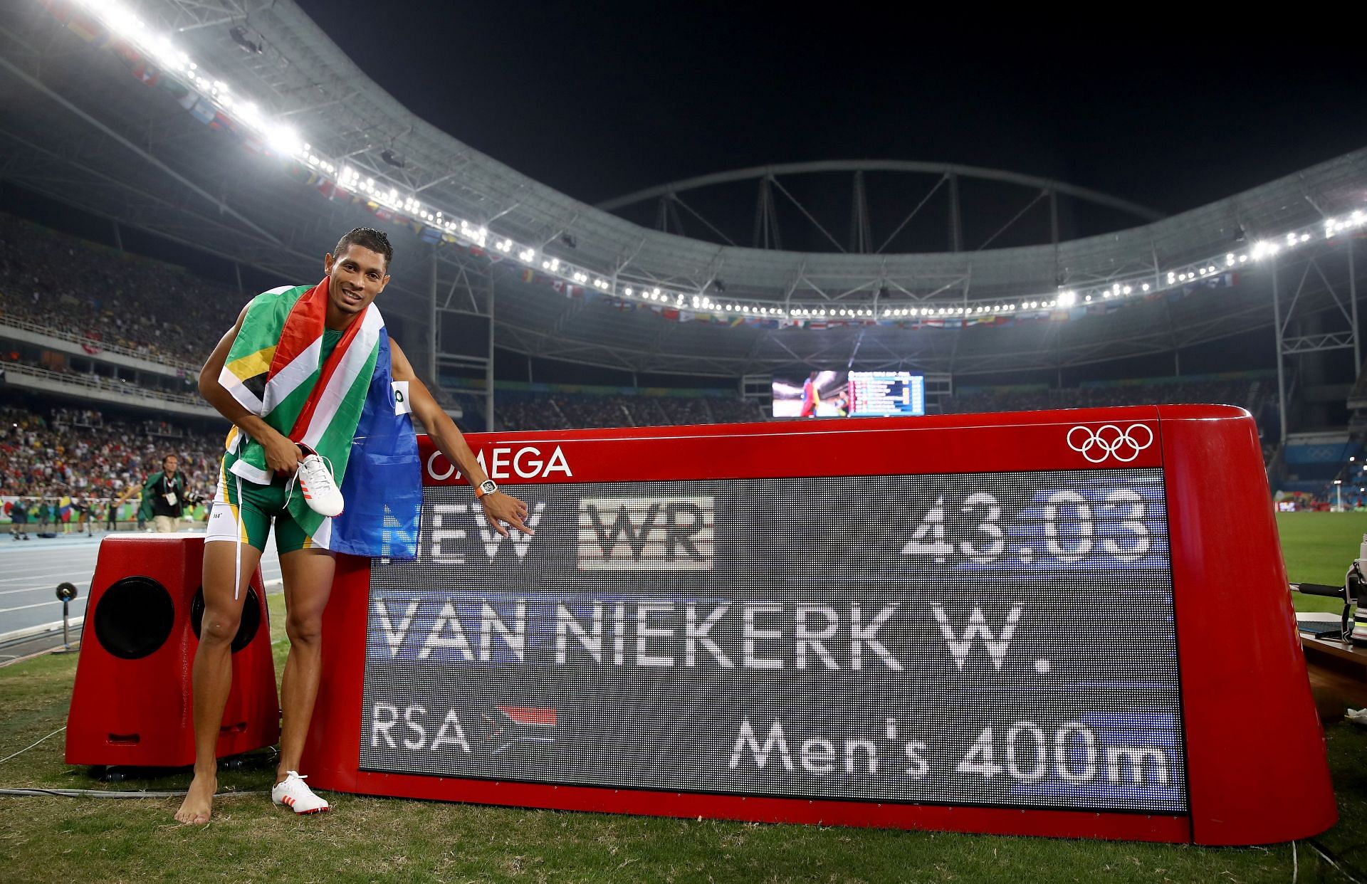 Wayde van Niekerk posing with a board showing his 400m world record at the 2016 Olympics in Rio de Janeiro.