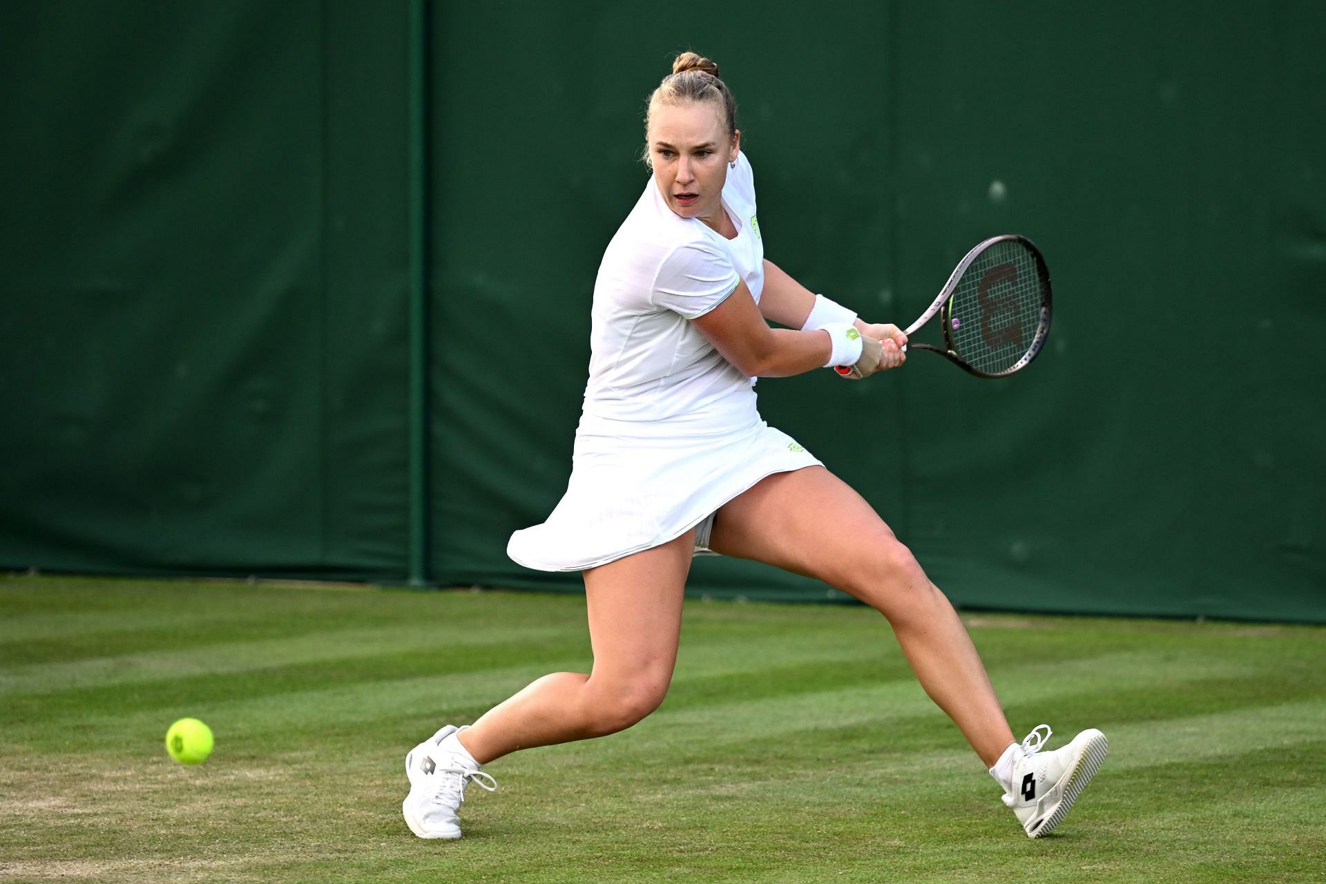 Anna Blinkova plays a backhand at Wimbledon 2023