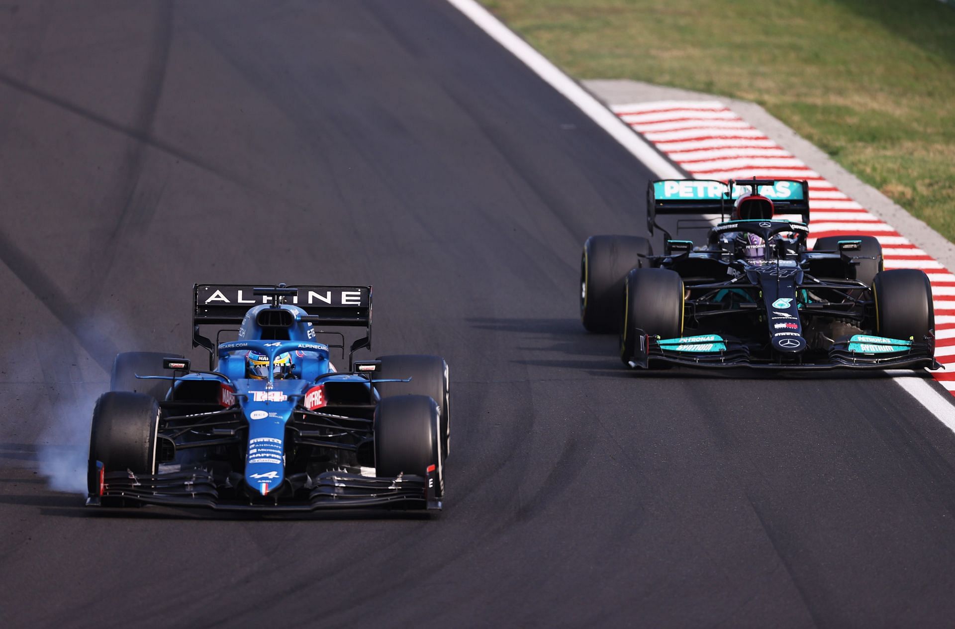 Fernando Alonso locks-up while defending from Lewis Hamilton during the 2021 F1 Hungarian Grand Prix (Photo by Lars Baron/Getty Images)