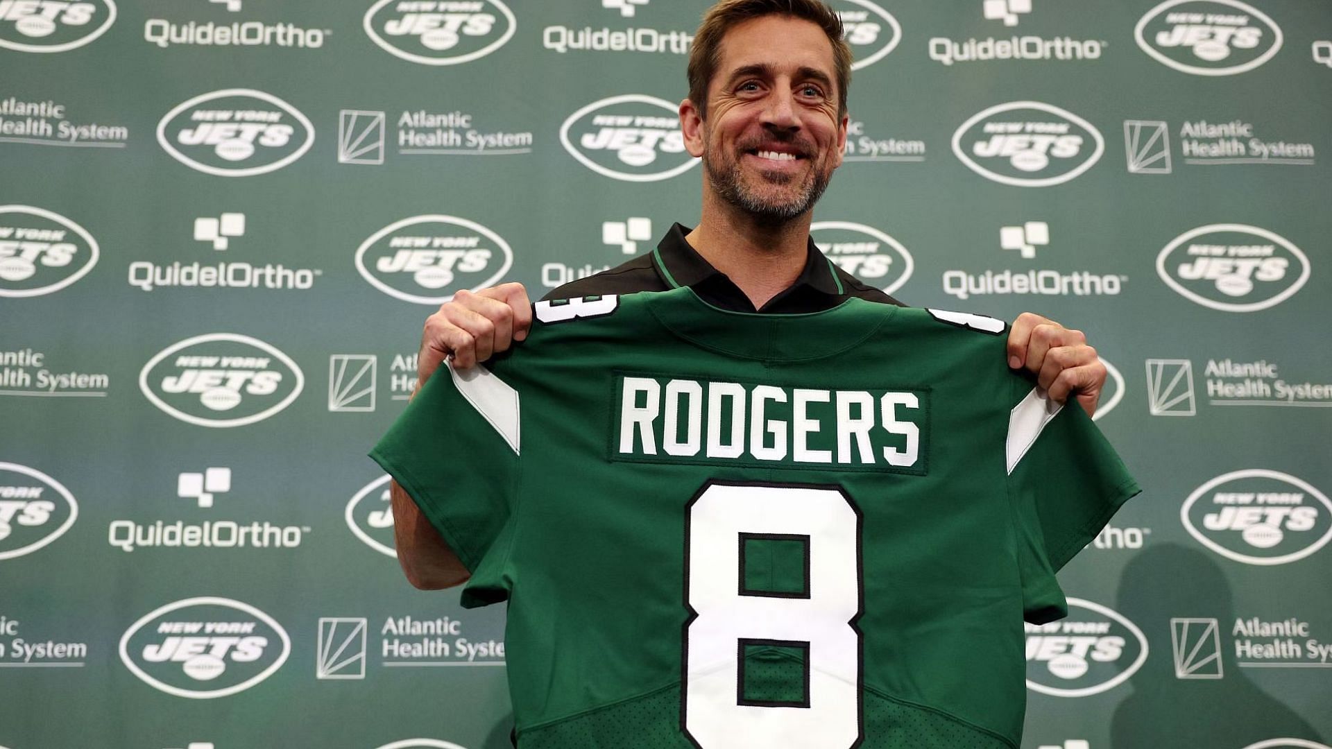 New York Jets quarterback Aaron Rodgers poses with a jersey during an introductory press conference at Atlantic Health Jets Training Center on April 26, 2023 in Florham Park, New Jersey.