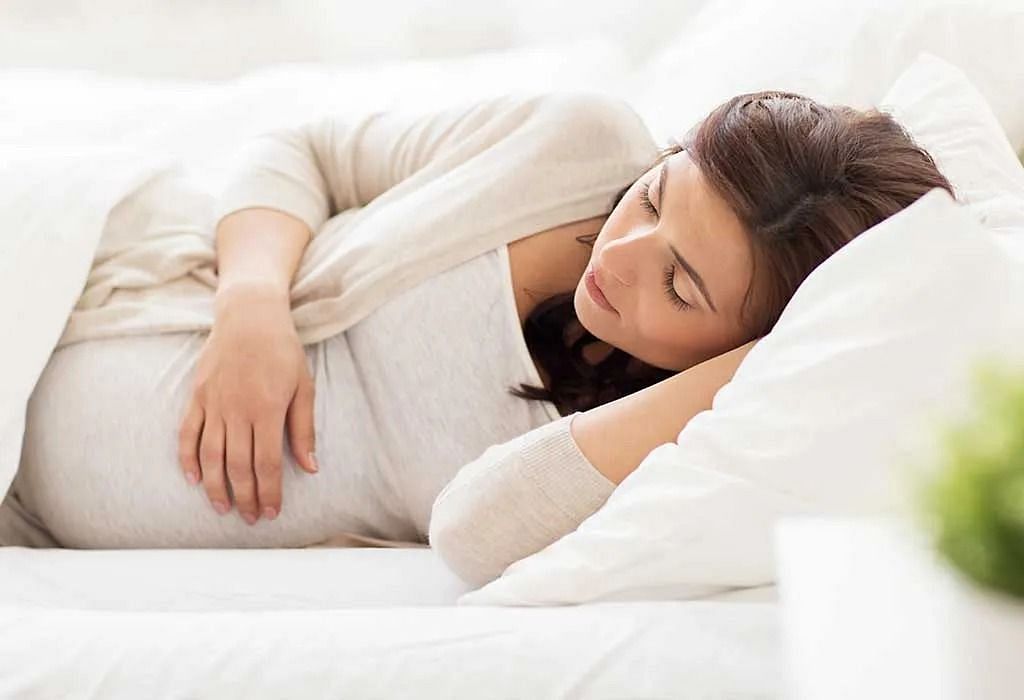 A pregnant lady sleeping on her left side (Image via Getty Images)