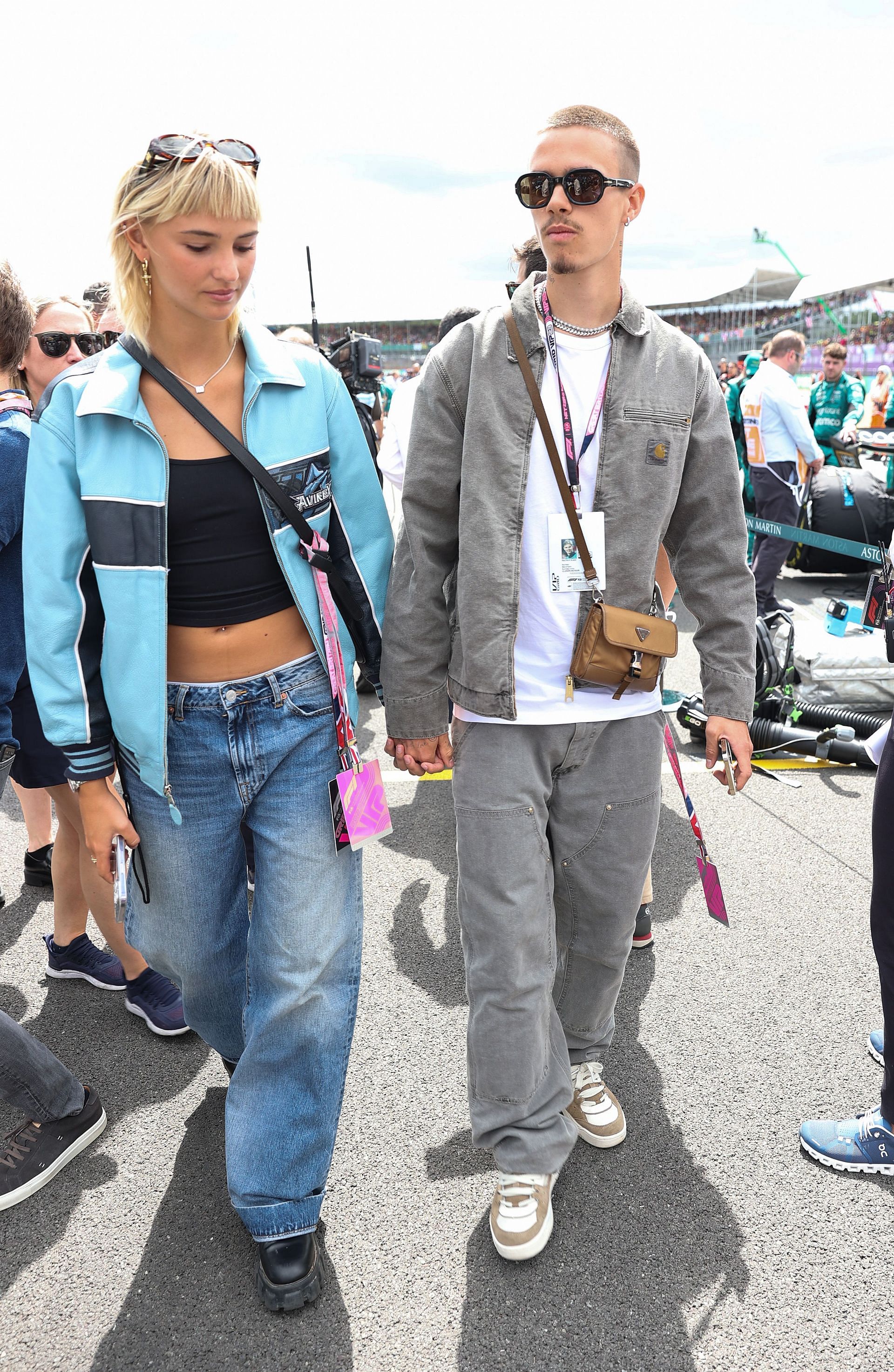 Romeo Beckham and Mia Regan walk down the F1 paddock (Photo by Ryan Pierse/Getty Images)