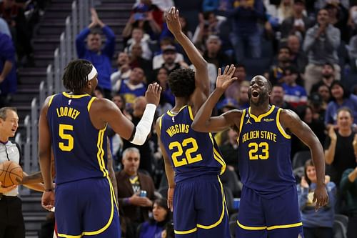 Kevon Looney, Andrew Wiggins and Draymond Green of the Golden State Warriors