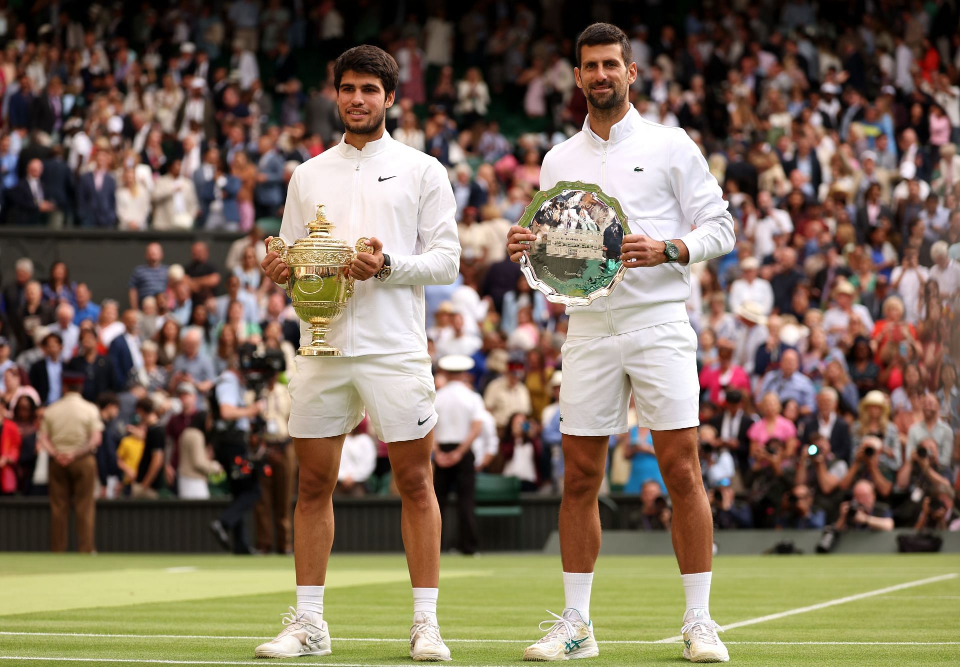 Carlos Alcaraz and Novak Djokovic pictured with their Wimbledon trophies.