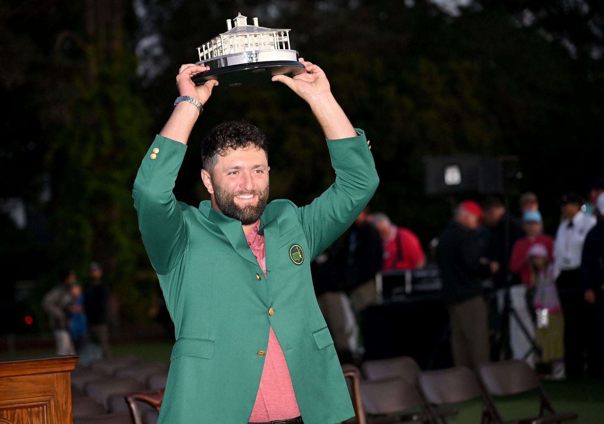 Rahm wearing the green jacket and holding the Masters Trophy in 2023 (via Getty Images)