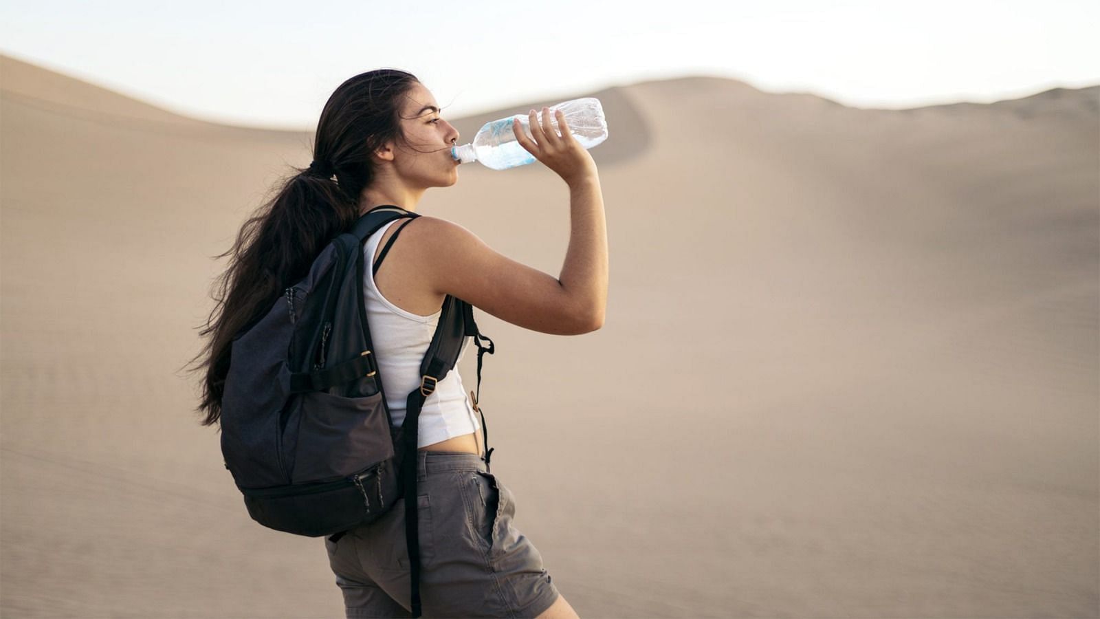 Drinking water to prevent constipation when traveling (Image via Getty Images)