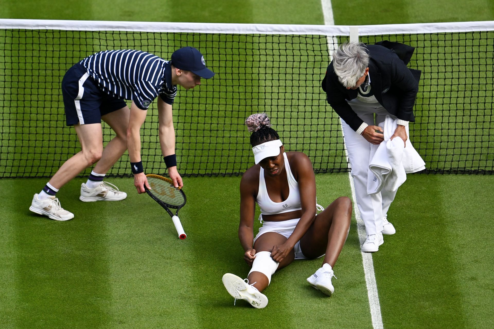 Venus Williams falls during her first-round match at Wimbledon 2023.