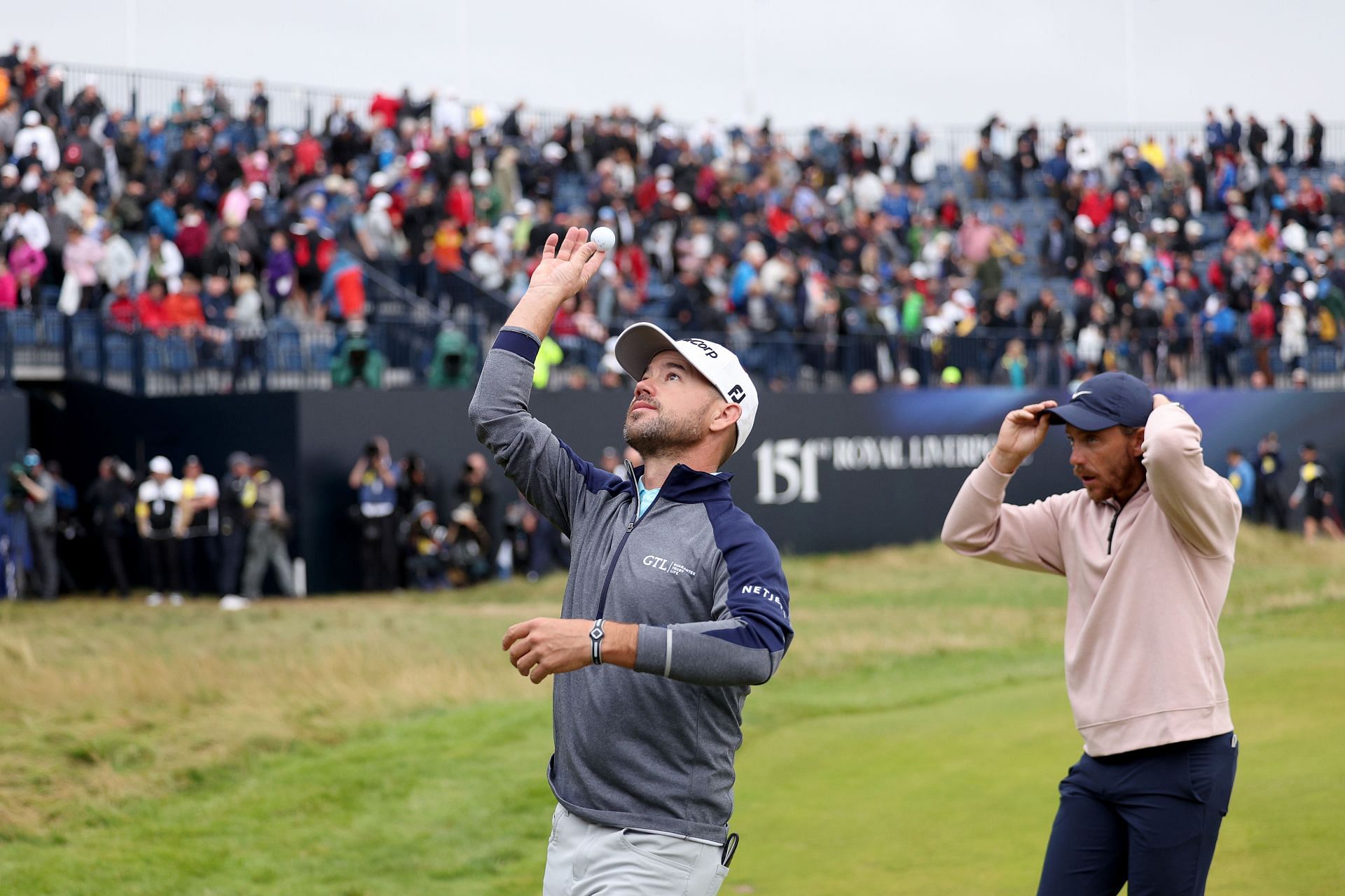 Brian Harman throws his match ball into the crowd after finishing on the 18th green at the Open Championship, day 3