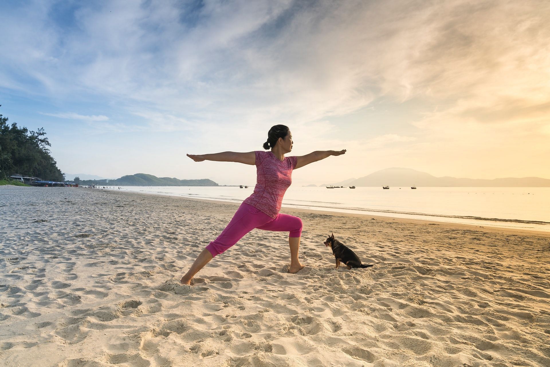 Two women doing yoga in Revolved Warrior 2 Pose (Virabhadrasana II) on beach,  Newport, Rhode Island, USA stock photo