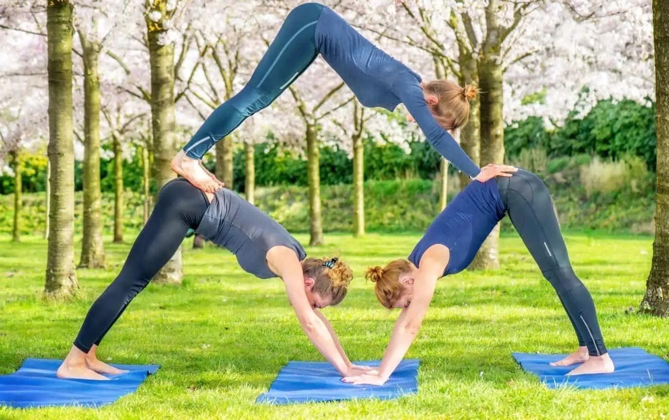 Trio downward-facing dog pose (Image via Getty Images)