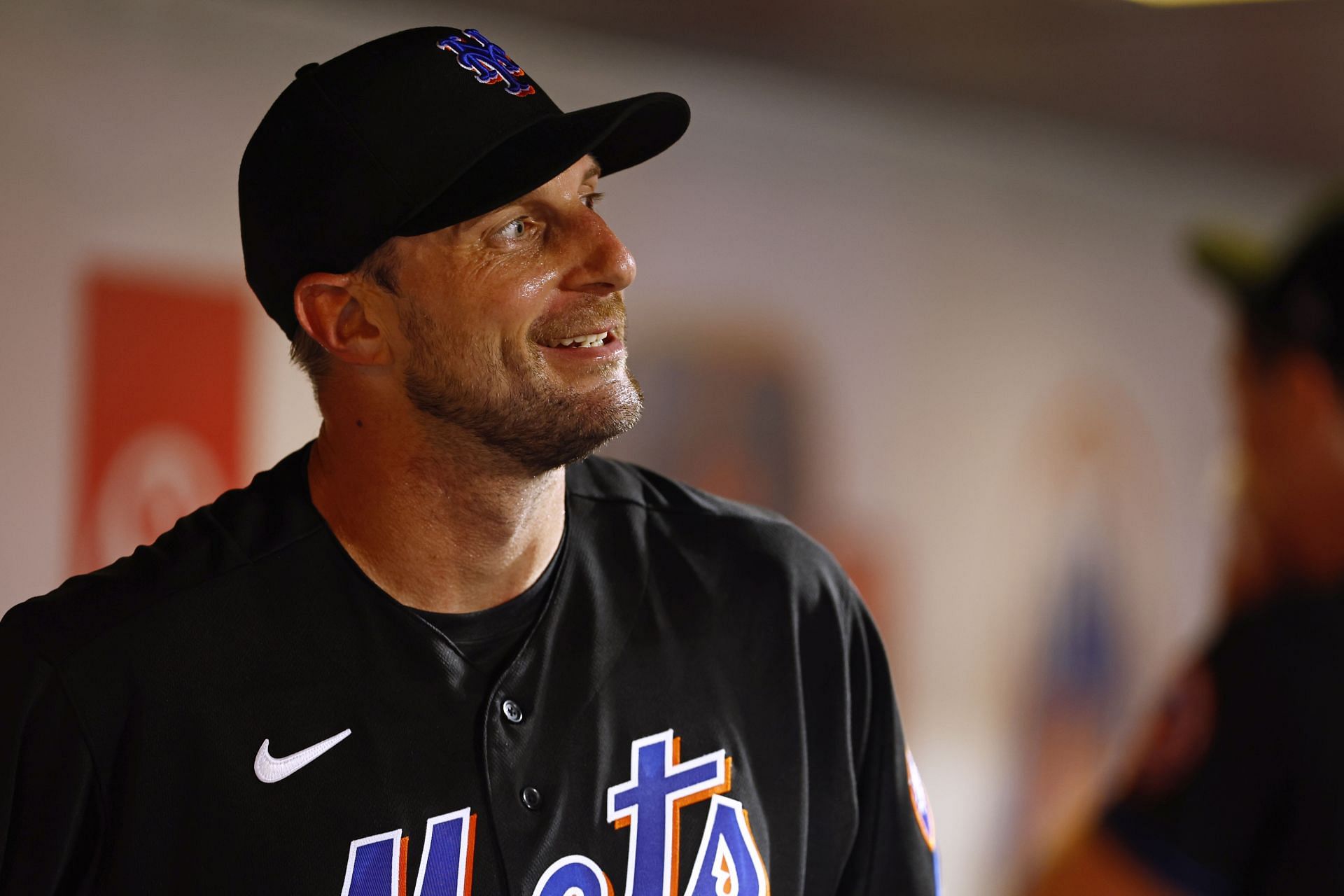 Pitcher Max Scherzer of the New York Mets smiles in the dugout against the Washington Nationals at Citi Field