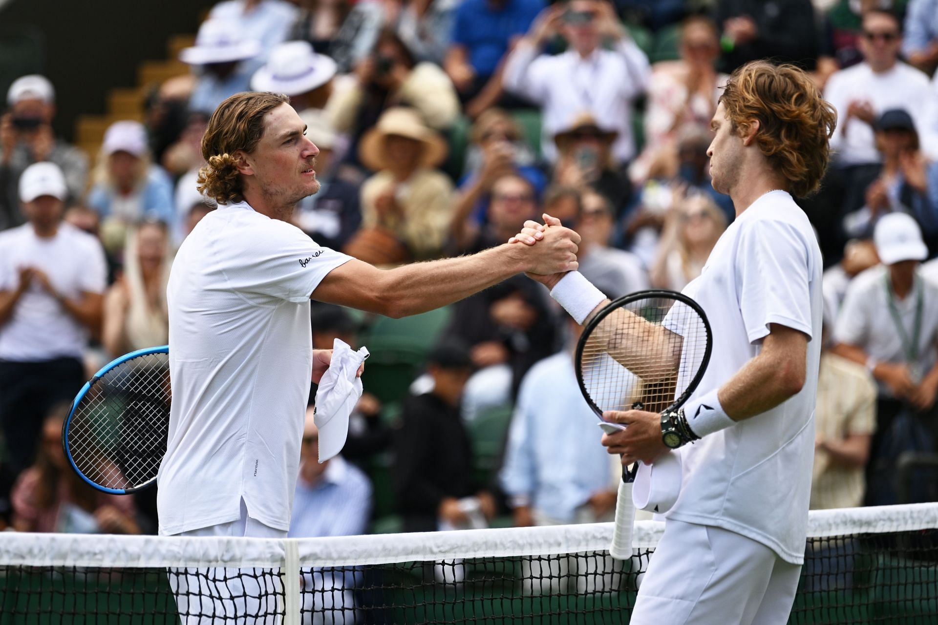 Max Purcell (L) and Andrey Rublev shake hands after their 2023 Wimbledon Championships clash.