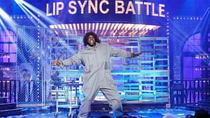 Watch: Shaquille O'Neal dons a jumpsuit and a wig to perform "Maniac" on Comedy Central