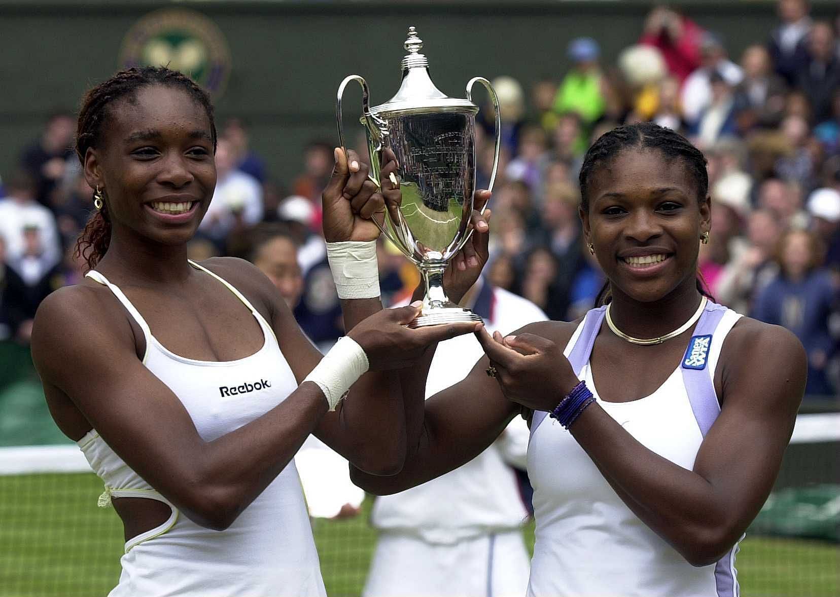 Venus Williams (L) &amp; Serena Williams with the women&#039;s doubles trophy in 2000