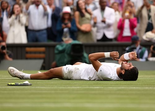 Carlos Alcaraz falls to the ground after winning