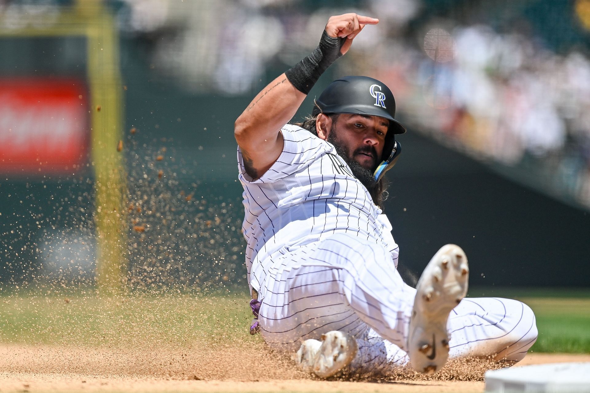 Jorge Alfaro slides safely to third base on a sacrifice fly during a game against the Los Angeles Angels at Coors Field