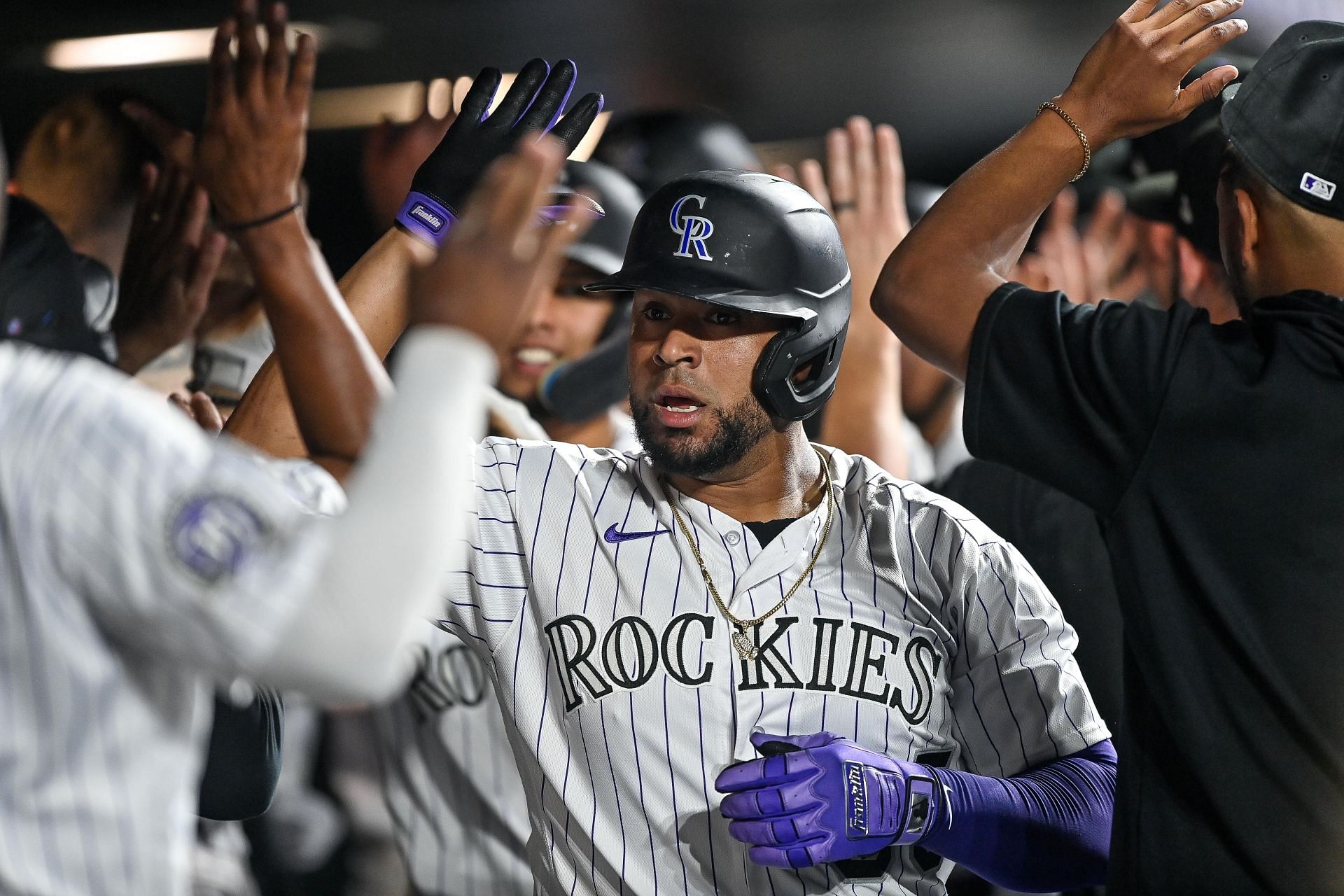 Elias Diaz of the Colorado Rockies is congratulated in the dugout at Coors Field