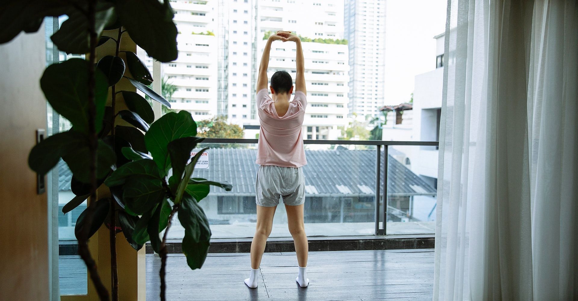Overhead arm stretch is one of the best stretches for upper back pain. (Photo via Pexels/Michelle Leman)