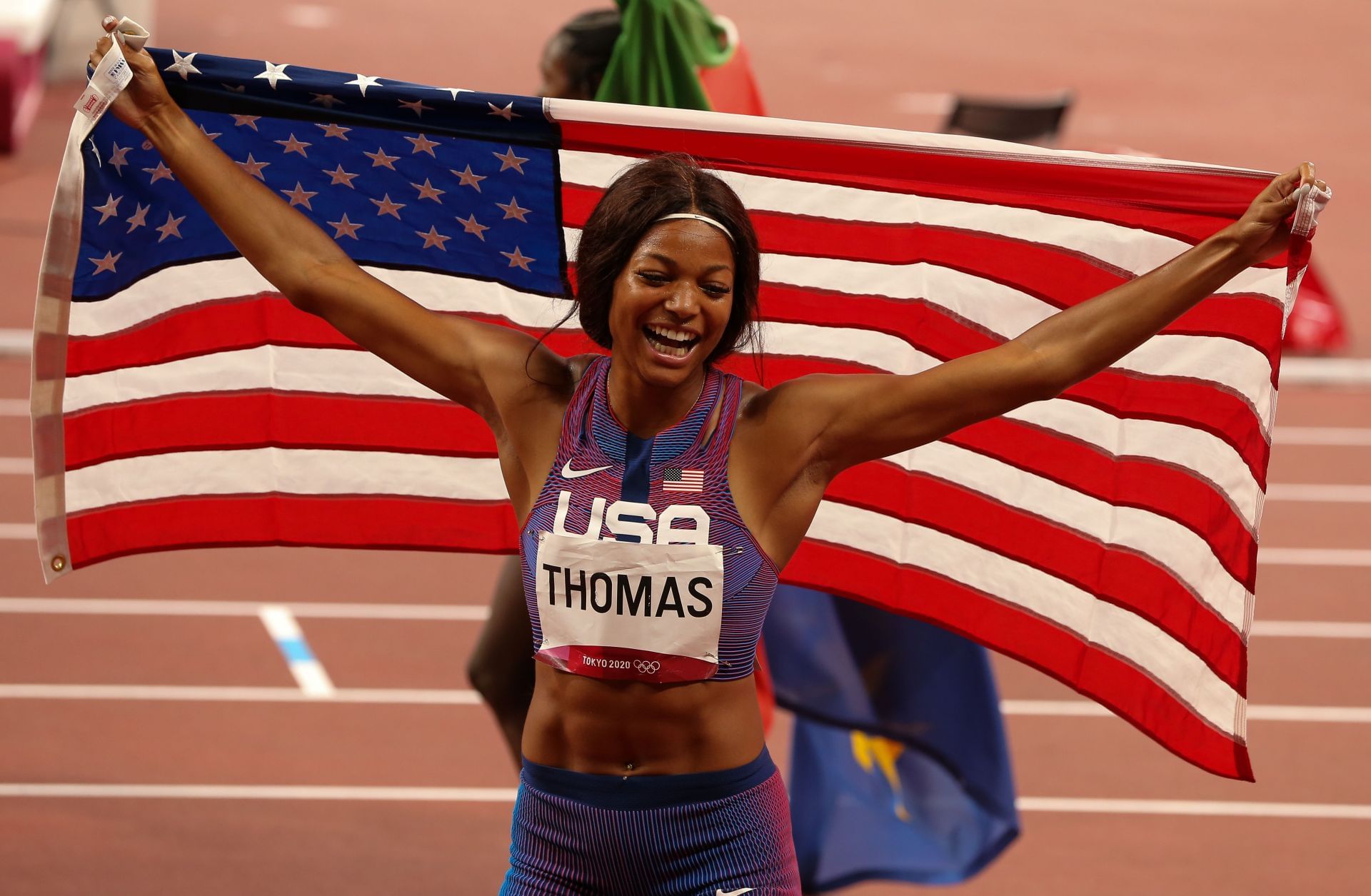 Gabrielle Thomas of the USA celebrates her bronze medal with her national flag after finishing third in the women's 200m final during the Athletics event on Day 11 of the Tokyo 2020 Olympic Games