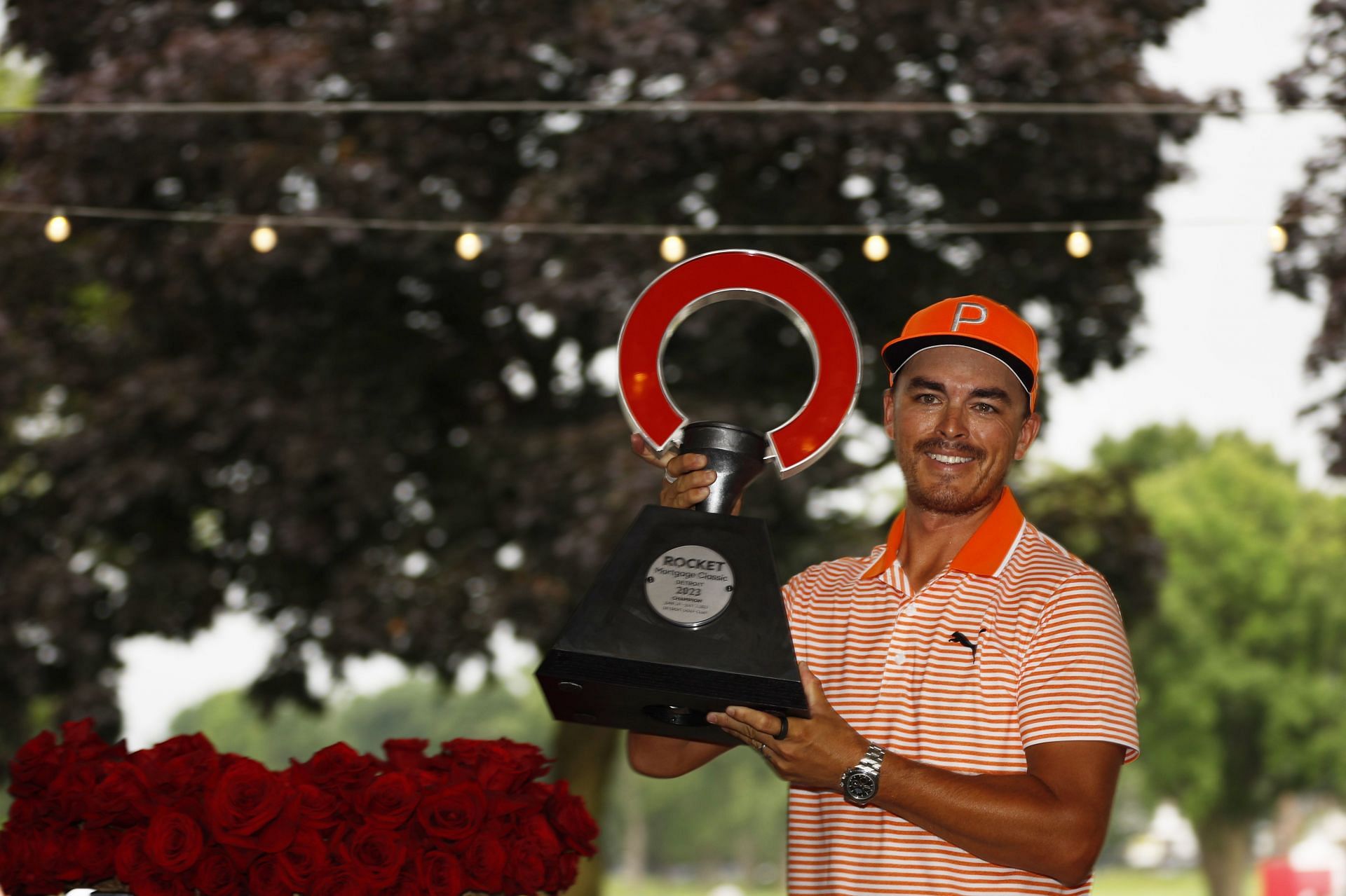 Rickie Fowler poses with the trophy after winning the Rocket Mortgage Classic in a playoff