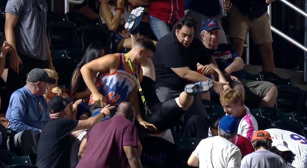 A Fan tumbles down the seats while trying to catch a foul ball by Abraham Almonte