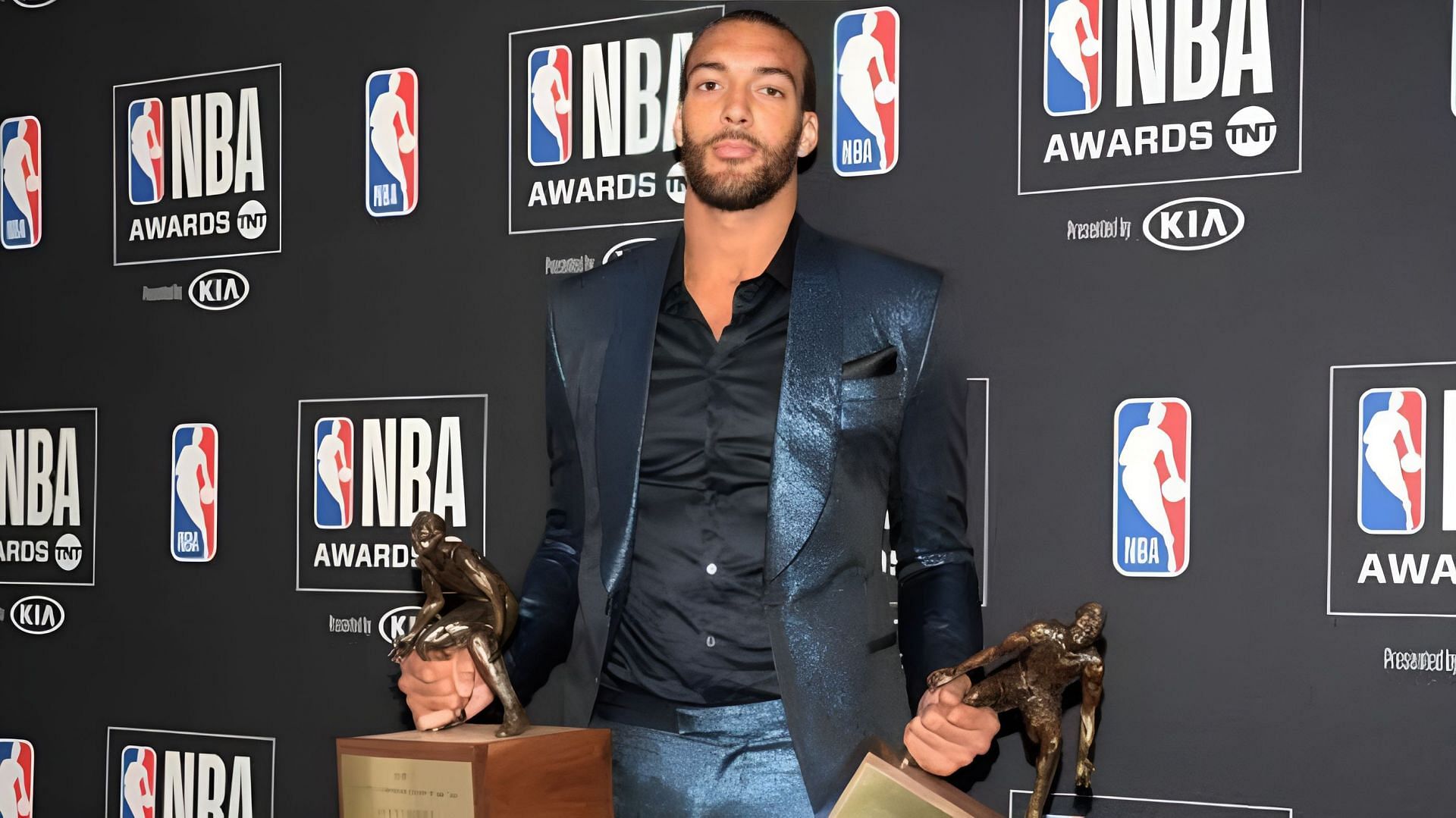 Former Utah Jazz star center Rudy Gobert holding two of his DPOTY trophies