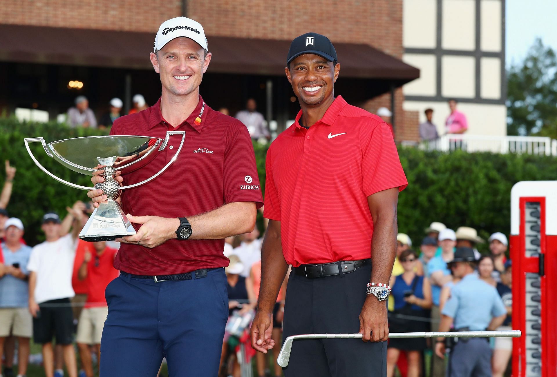 Justin Rose poses with the trophy alongside Tiger Woods after winning the 2018 Playoffs