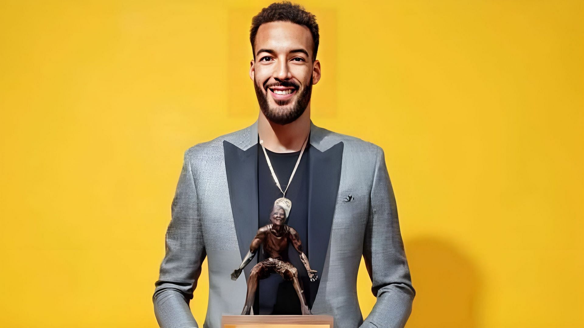 Former Utah Jazz star center Rudy Gobert holding one of his DPOTY trophies