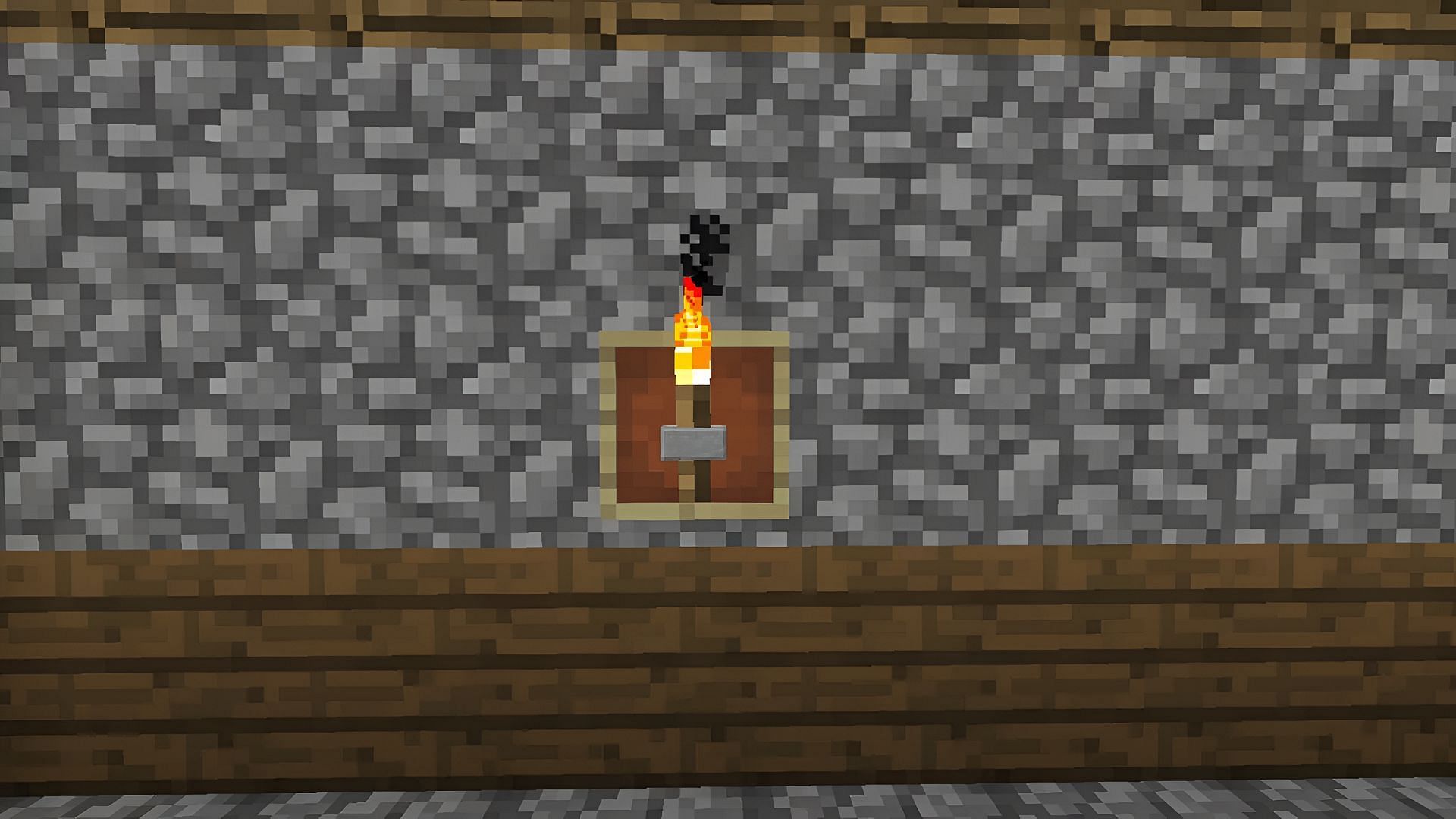 A torch is placed on a wall in Minecraft with an item frame and a button.