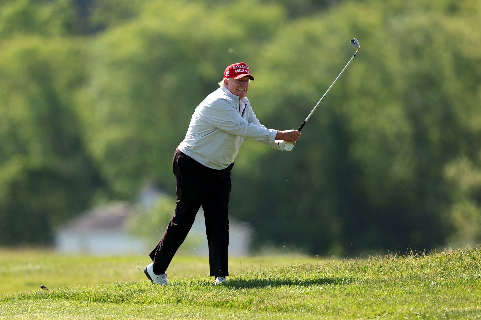 Former President Donald Trump plays a shot during the pro-am prior to the LIV Golf DC